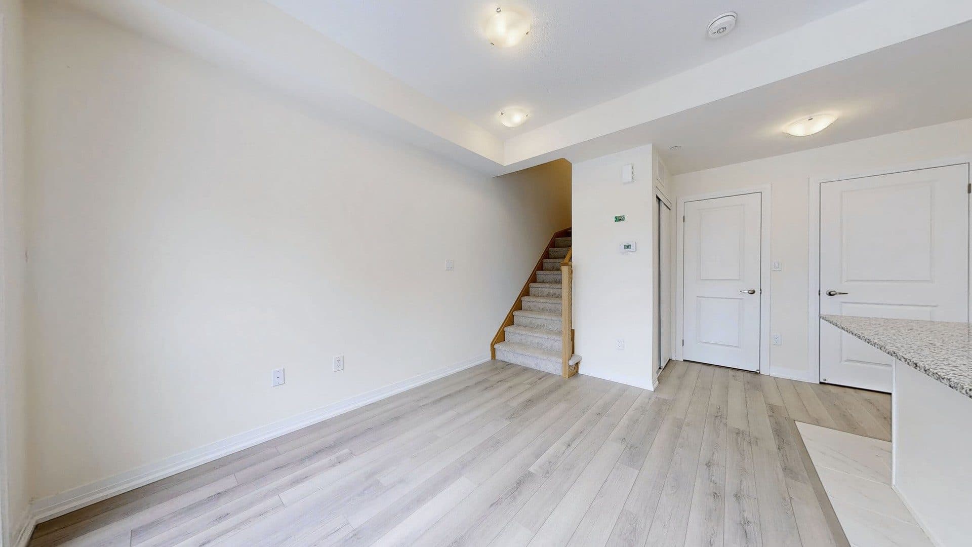 Spacious Living Room with Staircase at Rental Listing in Scarborough, a 1 bedroom rental in 165 Tapscott Road, Scarborough, ON, listed for $1,000 per month