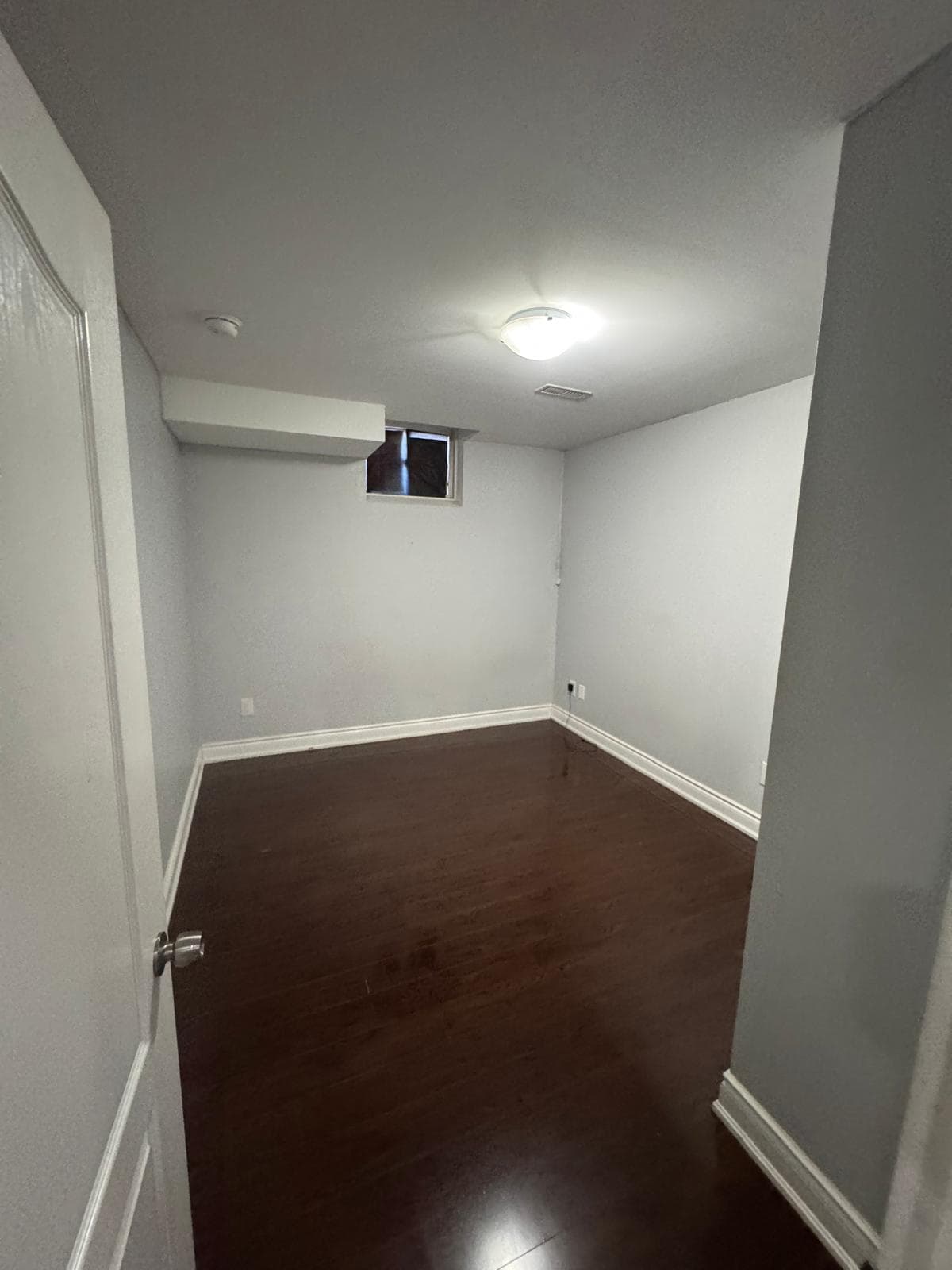 Empty Room with Dark Wood Flooring at 2 Bedroom Basement Apartment in Brampton for $1,400, a 2 bedroom rental in 47 Speedwell Street, Brampton, Ontario (ON), listed for $1,400 per month
